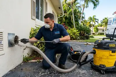 Technician cleaning dryer vent system at North Miami Beach FL home for Five Star Cooling service